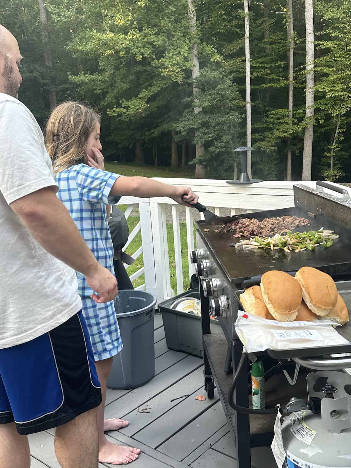 dad and daughter grilling philadelphia cheesesteaks