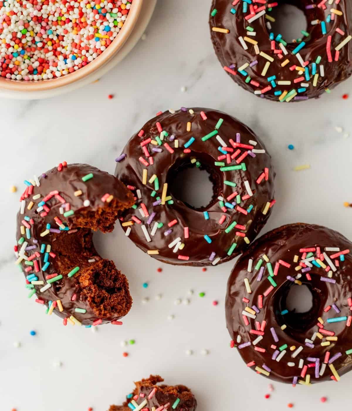 baked chocolate donuts with greek yogurt sprinkled with rainbow sprinkles