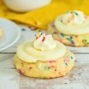 funfetti cookie topped with whipped cream and vanilla icing on a white serving platter