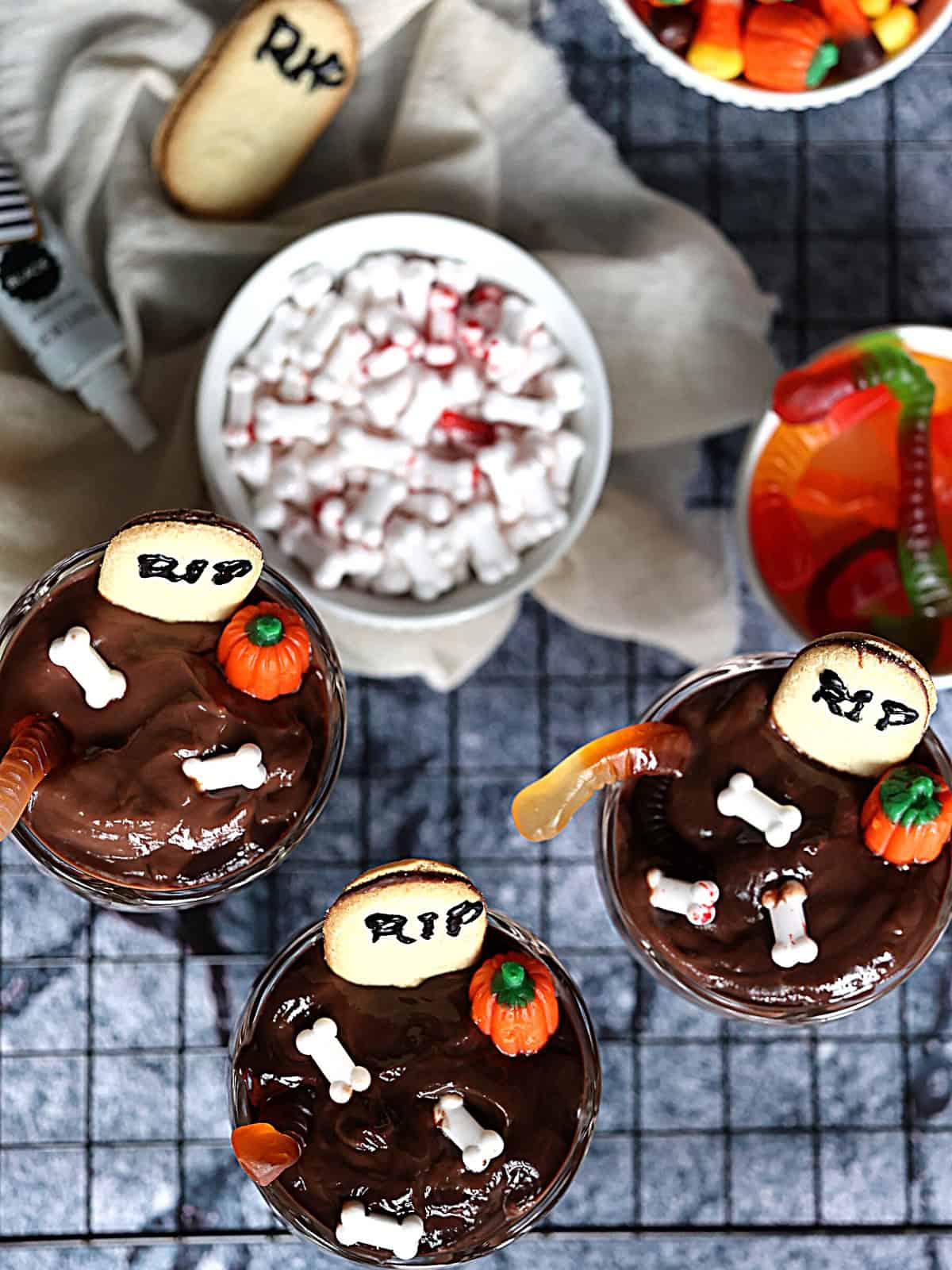 halloween pudding cup topped with crushed oreos and a cookie tombstone
