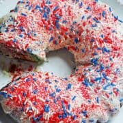 vanilla glazed bundt cake topped with red, white and blue sprinkles