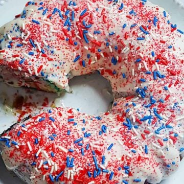 vanilla glazed bundt cake topped with red, white and blue sprinkles