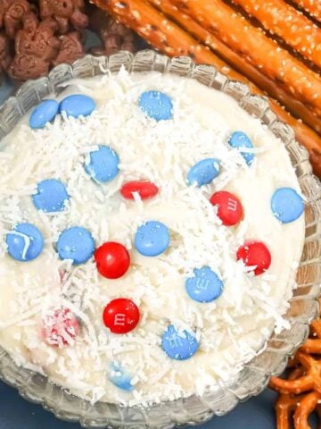 cream cheese dip topped with candy pieces and coconut flakes