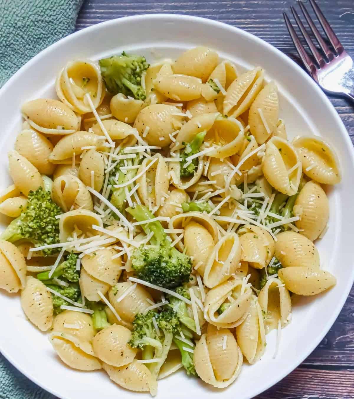 garlic pasta broccoli with parmesan cheese in a white plate