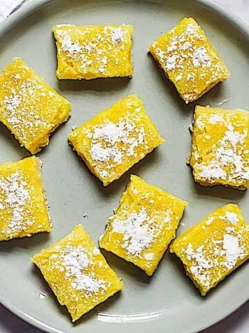 creamy lemon bars on a gray plate
