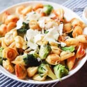 tortellini and broccoli in a white bowl
