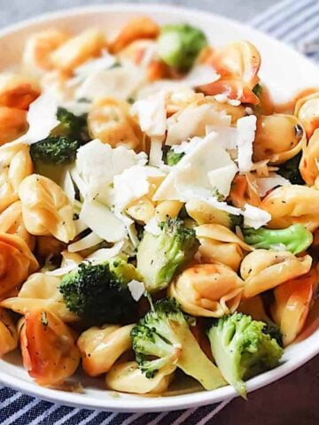 tortellini and broccoli in a white bowl