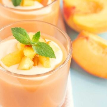 banana peach smoothie in a glass with mint leaves